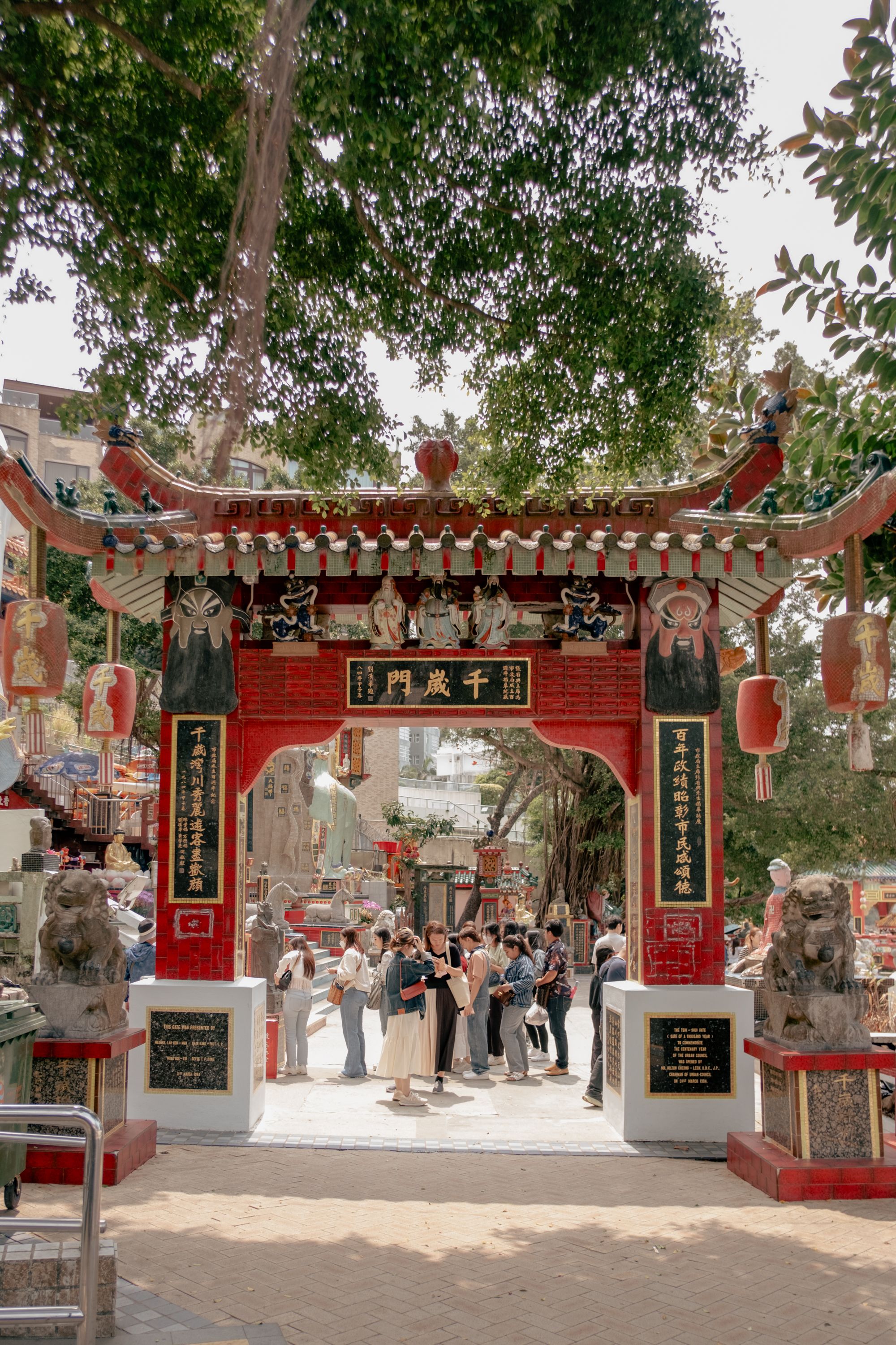 Visitors gather at the colorful entrance of Wong Tai Sin Temple in Hong Kong, a popular cultural landmark.