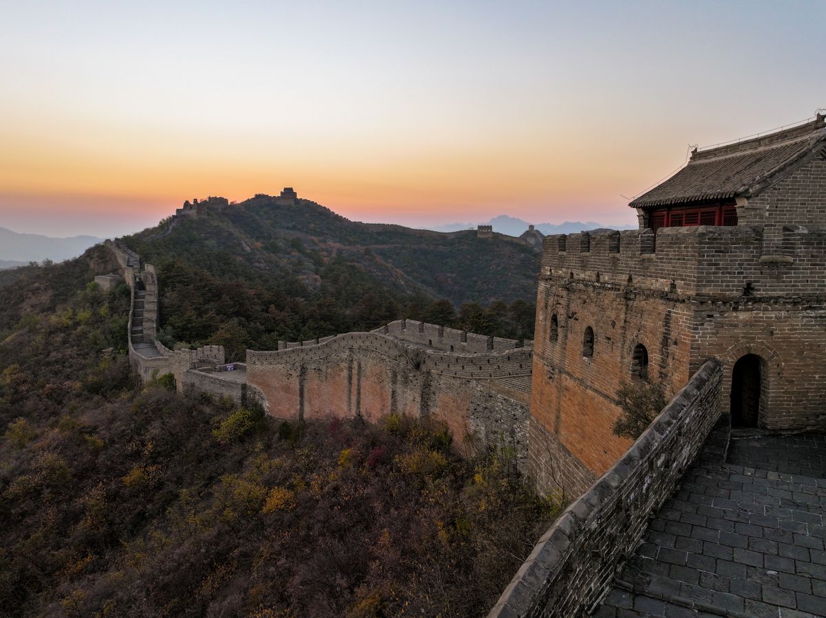 夕暮れの空の下に続く古代中国の城壁のイメージ
