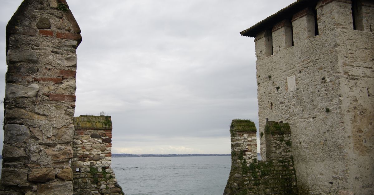 Antigos muros de pedra do Castelo Scaliger em Sirmione, Itália, com vista para o Lago de Garda.