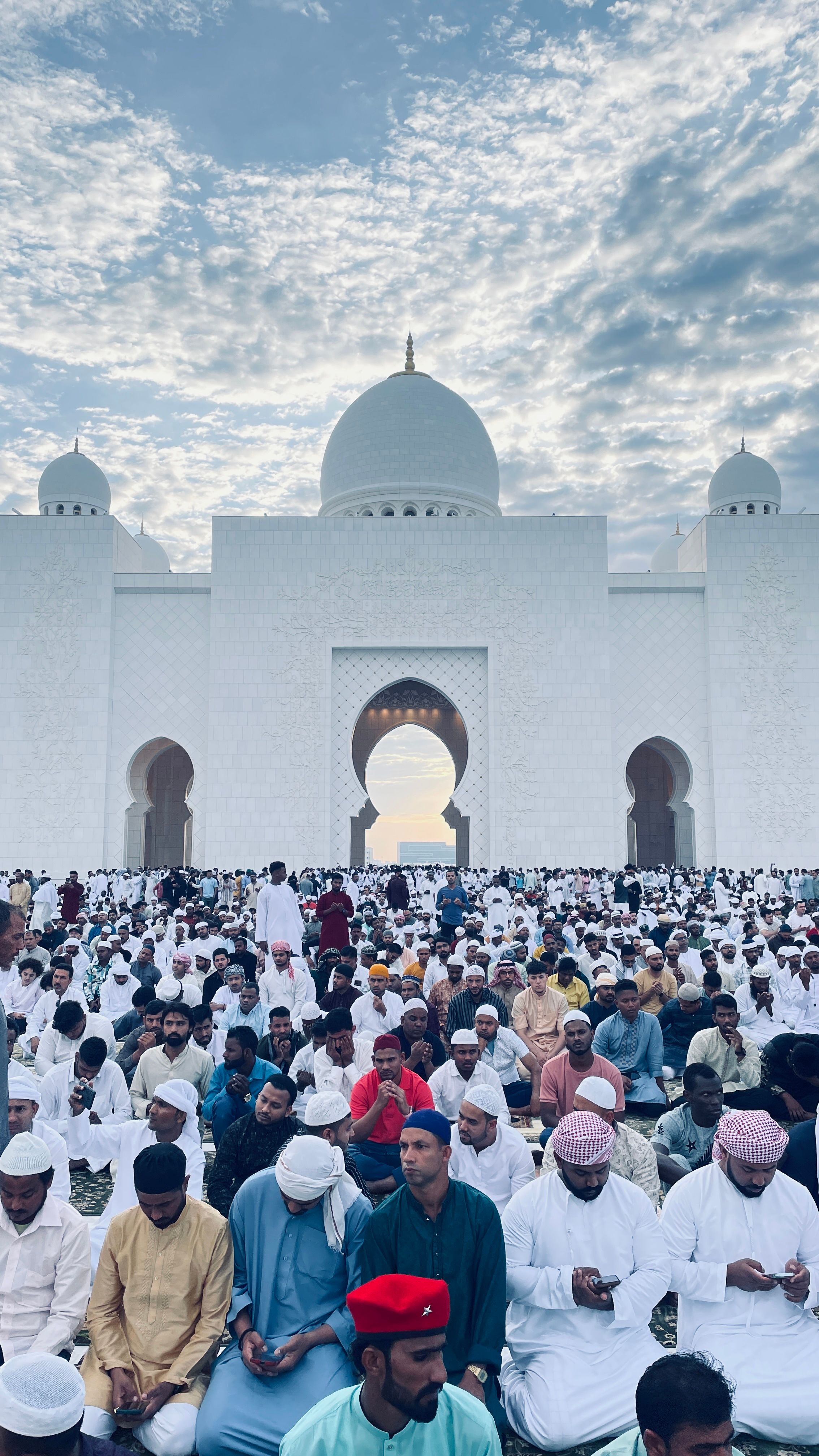 A large crowd gathers for prayer at the iconic Sheikh Zayed Grand Mosque in Abu Dhabi.
