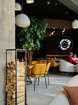 A modern cafe interior featuring cozy seating, warm lighting, and wood accents for a relaxing ambiance.