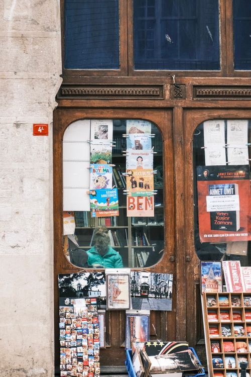 Free Charming vintage bookstore front with various books and postcards on display. Stock Photo