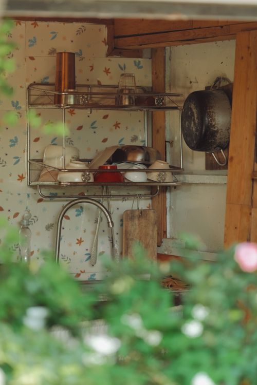 Free Cozy rustic kitchen scene with hanging pots and wooden shelving. Stock Photo