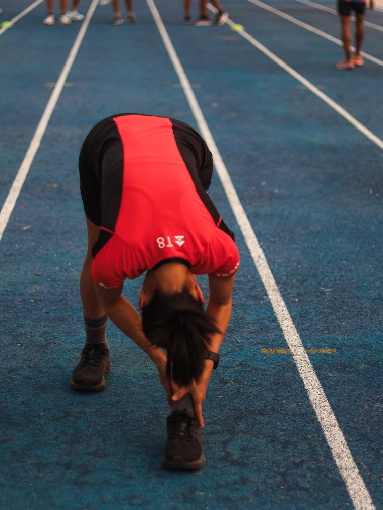 Sprinter preparing on a blue track before a race — photo by Nay Nyo on Pexels