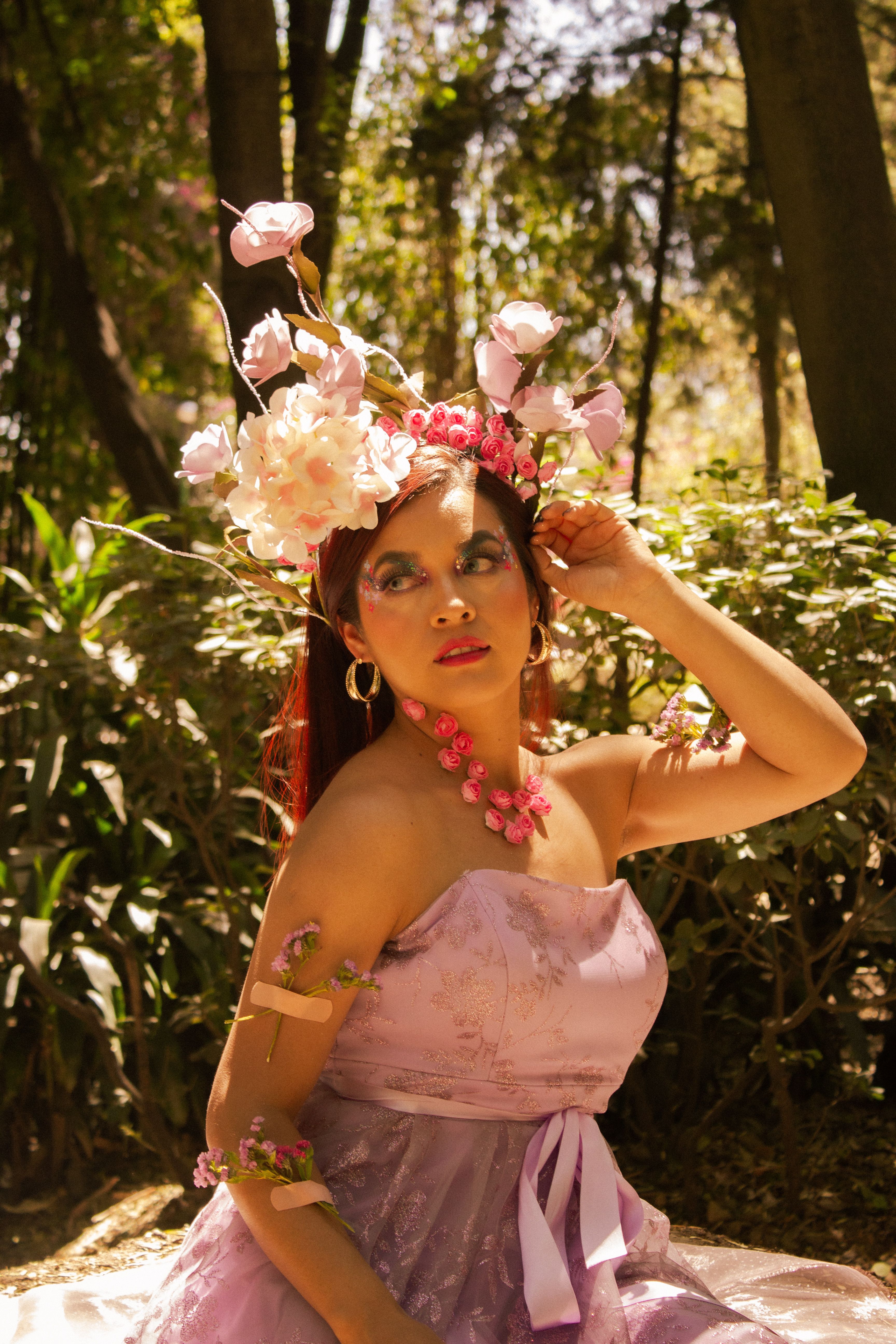 Fotomural Mujer con diadema floral en un entorno de bosque iluminado por el sol, personificando una belleza etérea.