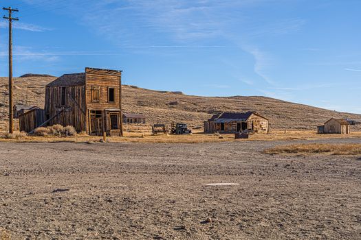 Explore this historic ghost town in Bridgeport, California with abandoned wooden buildings under a clear blue sky.