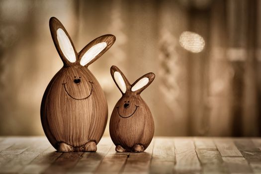 Wooden eggs in form of rabbits with big ears and lines with dots representing muzzle placed on table in room with artificial light during Easter holiday