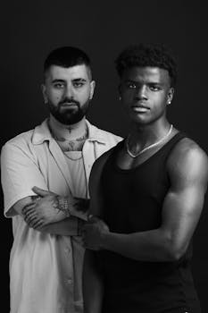 Powerful black and white portrait of two men posing with tattoos.