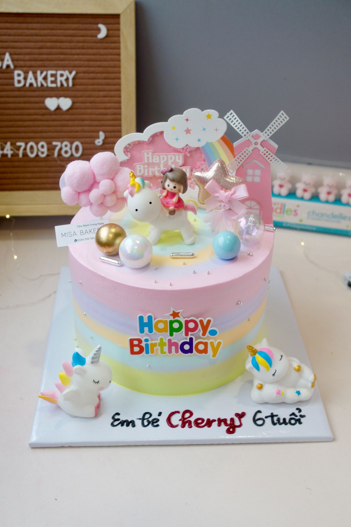 A vibrant unicorn-themed birthday cake with playful decorations and pastel colors.