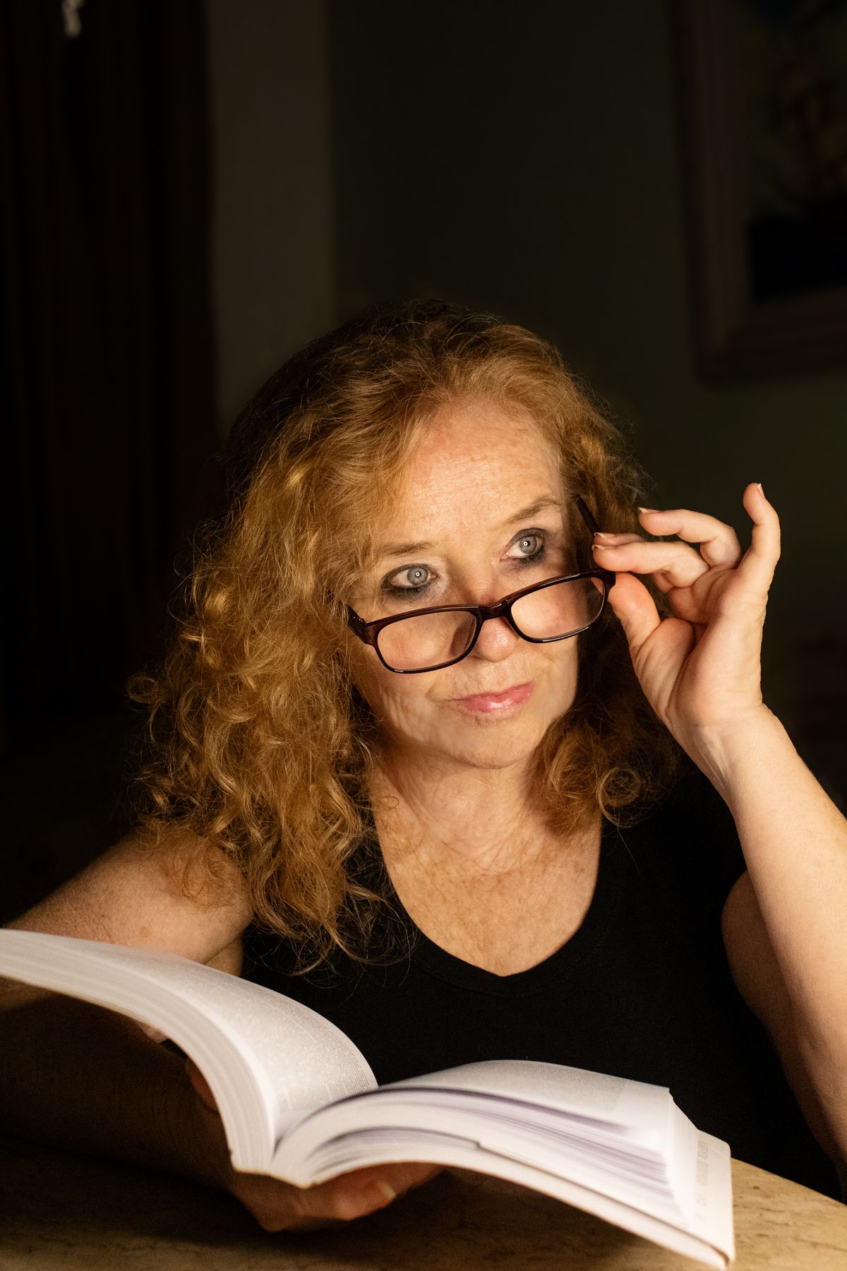 Mature woman reading while wearing reading glasses