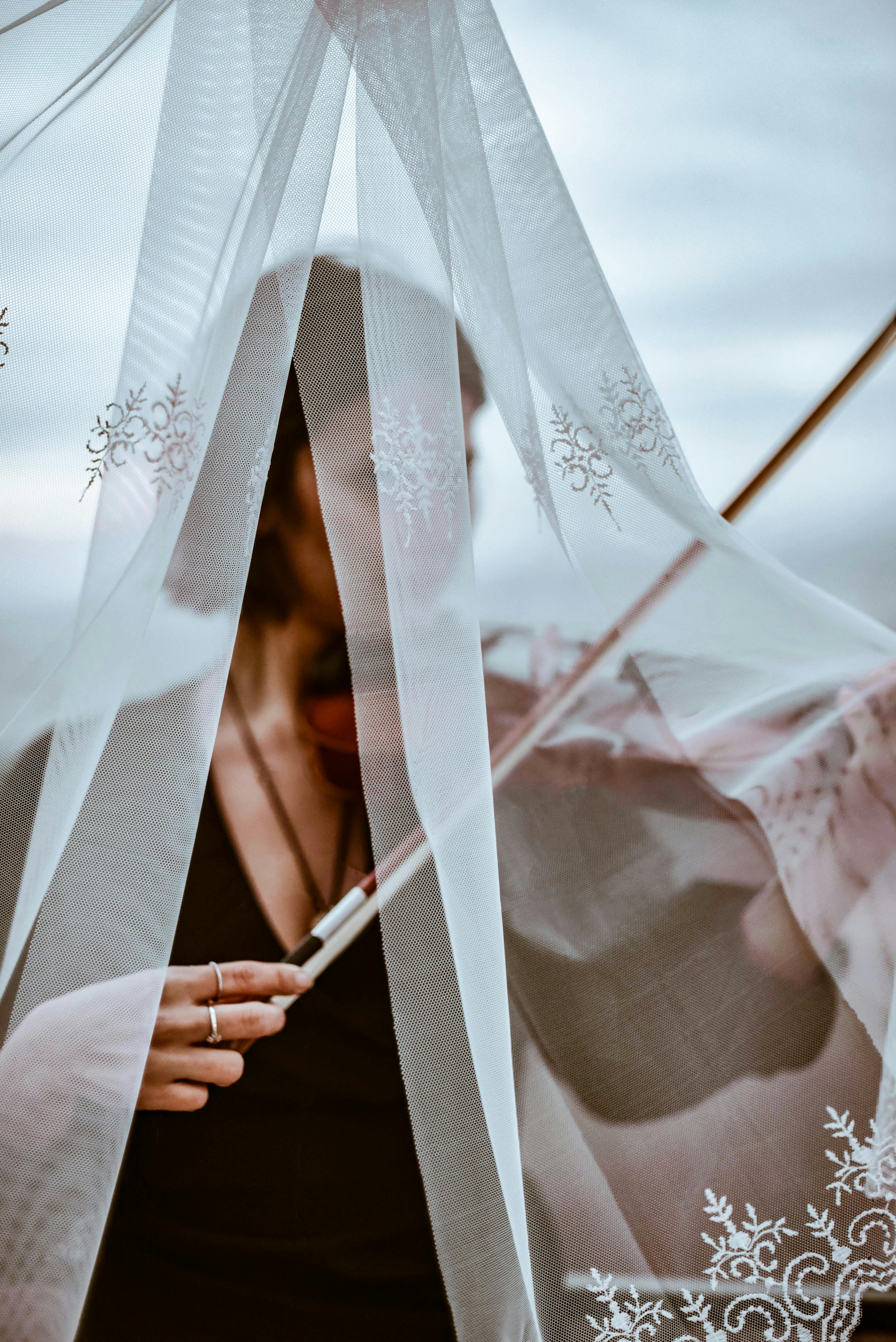 Elegant portrait of a violinist behind lace curtains, showcasing music and outdoor ambiance.
