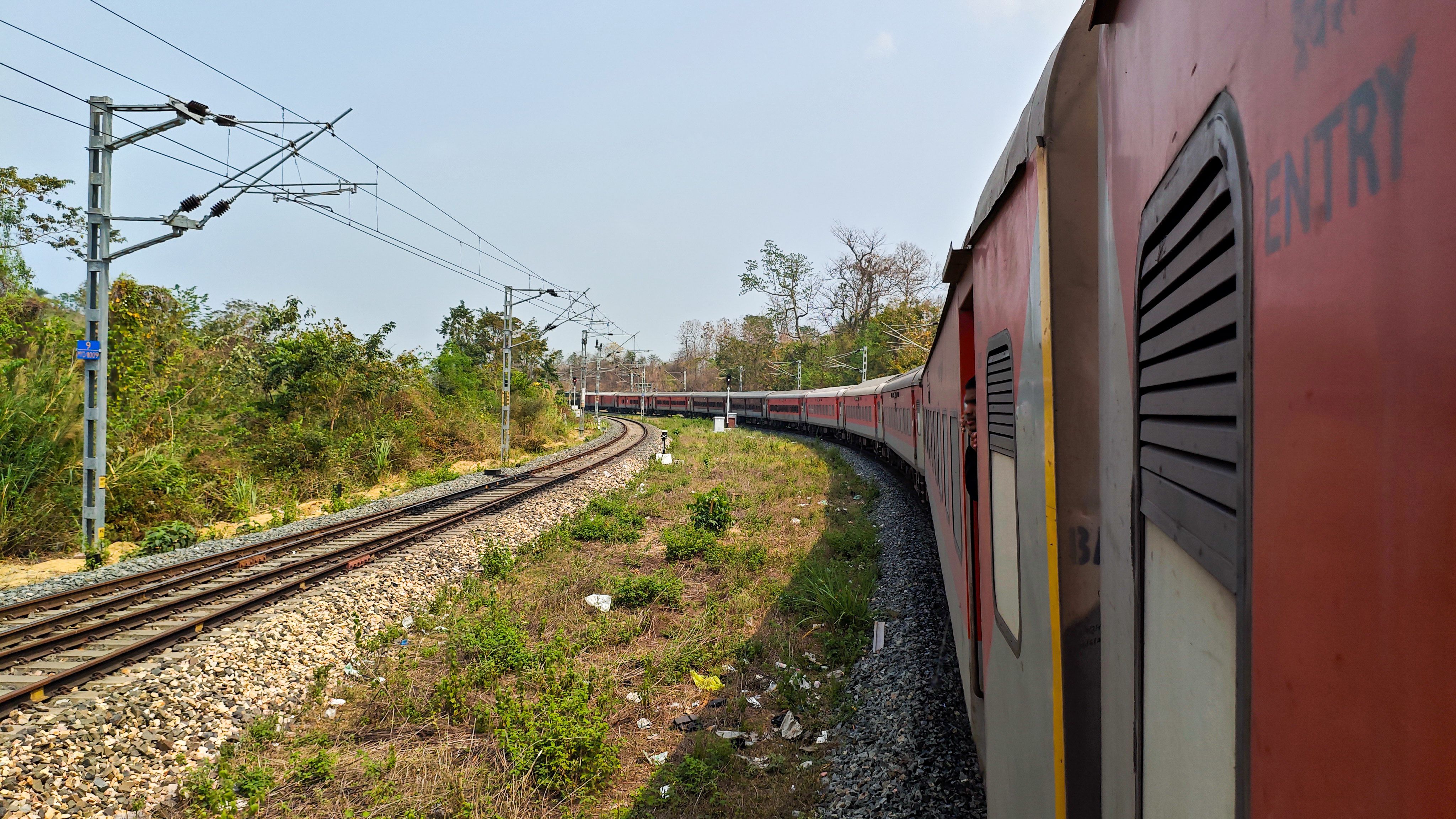 An Indian Railways train passing through a scenic landscape in India, symbolizing inter-regional travel