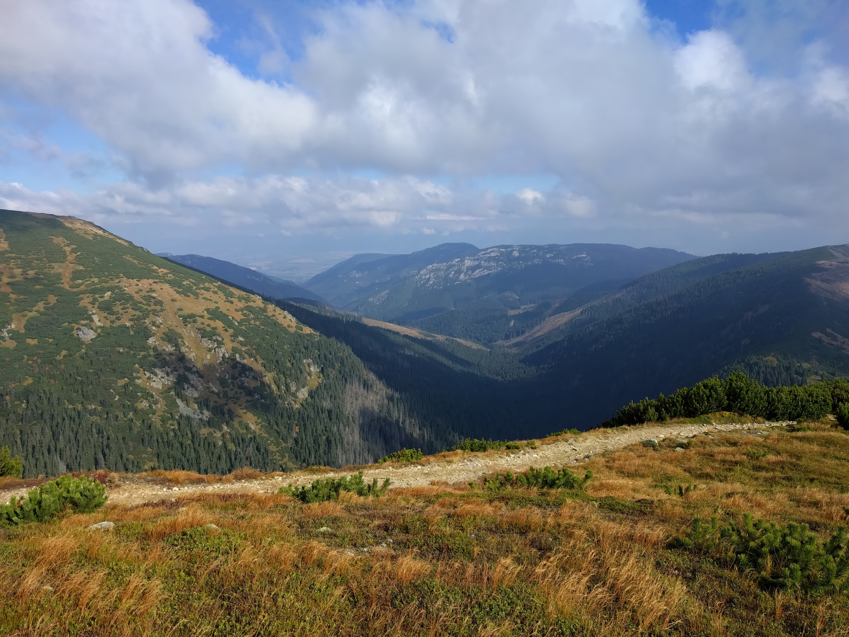 Beautiful view of a lush mountain range under a bright blue sky, perfect for nature enthusiasts. — free online jigsaw puzzle on JigsawPuzzlesFreeOnline.org