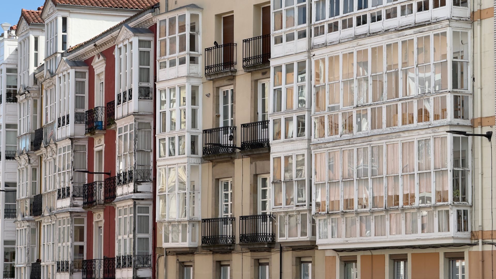 A stunning view of traditional Spanish apartments featuring characteristic glass-enclosed balconies in Vitoria-Gasteiz.
