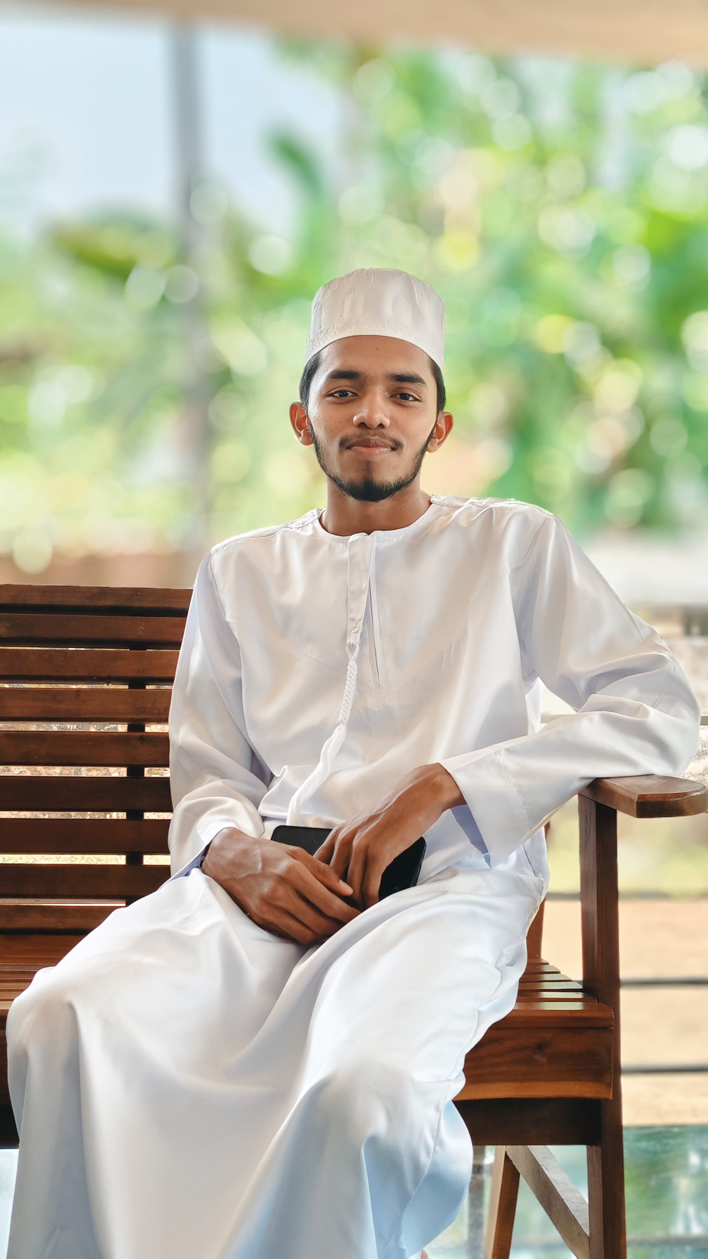 Young Man Relaxing on Wooden Bench Outdoors