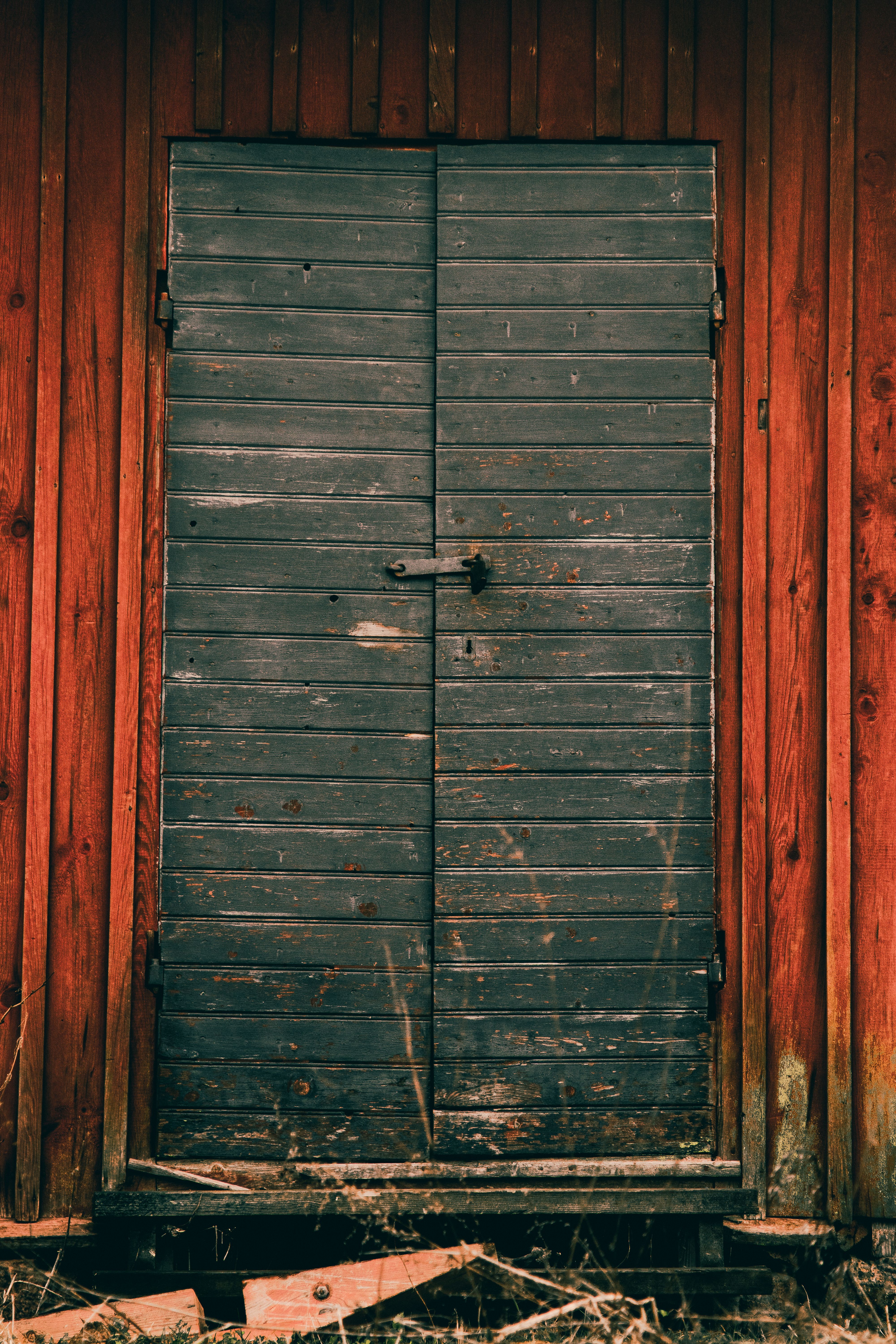 An old, weathered wooden door on a rustic red barn in Uppsala, Sweden.
