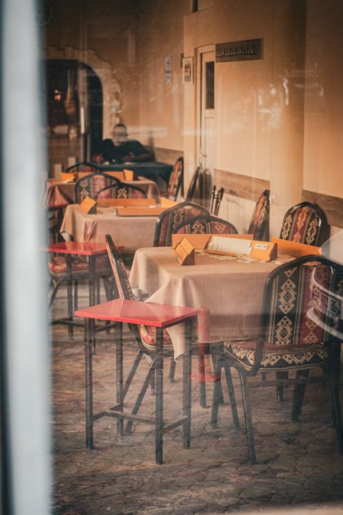Free Warm and inviting empty cafe with ethnic decor, softly lit interior view from outside. Stock Photo
