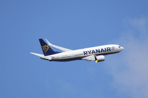 Free A Ryanair airplane captured in flight against a clear blue sky, showcasing modern air travel. Stock Photo