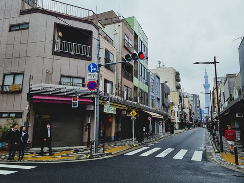 Free Street scene in Tokyo with pedestrians and the iconic Tokyo Skytree visible in the distance. Stock Photo