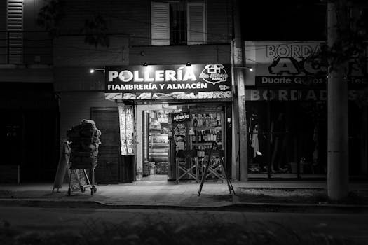 Black and white photo of a chicken shop at night in Córdoba, Argentina, showcasing urban nightlife.