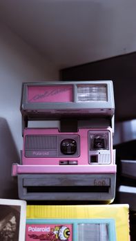 Retro pink Polaroid camera showcased indoors with nostalgic vibe.