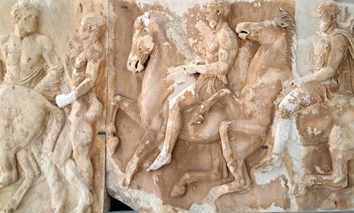 Free Detailed view of ancient Greek marble relief depicting riders and horses. Stock Photo