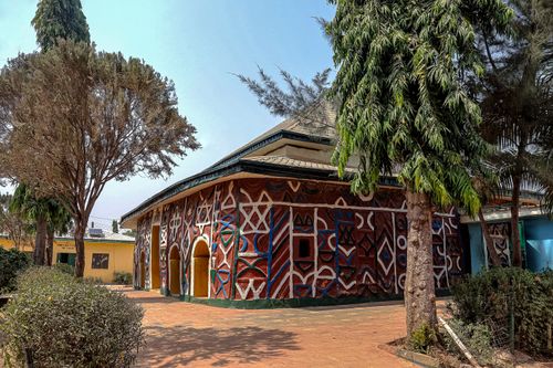 Free Vibrant traditional building facade with geometric patterns surrounded by trees in an outdoor setting. Stock Photo