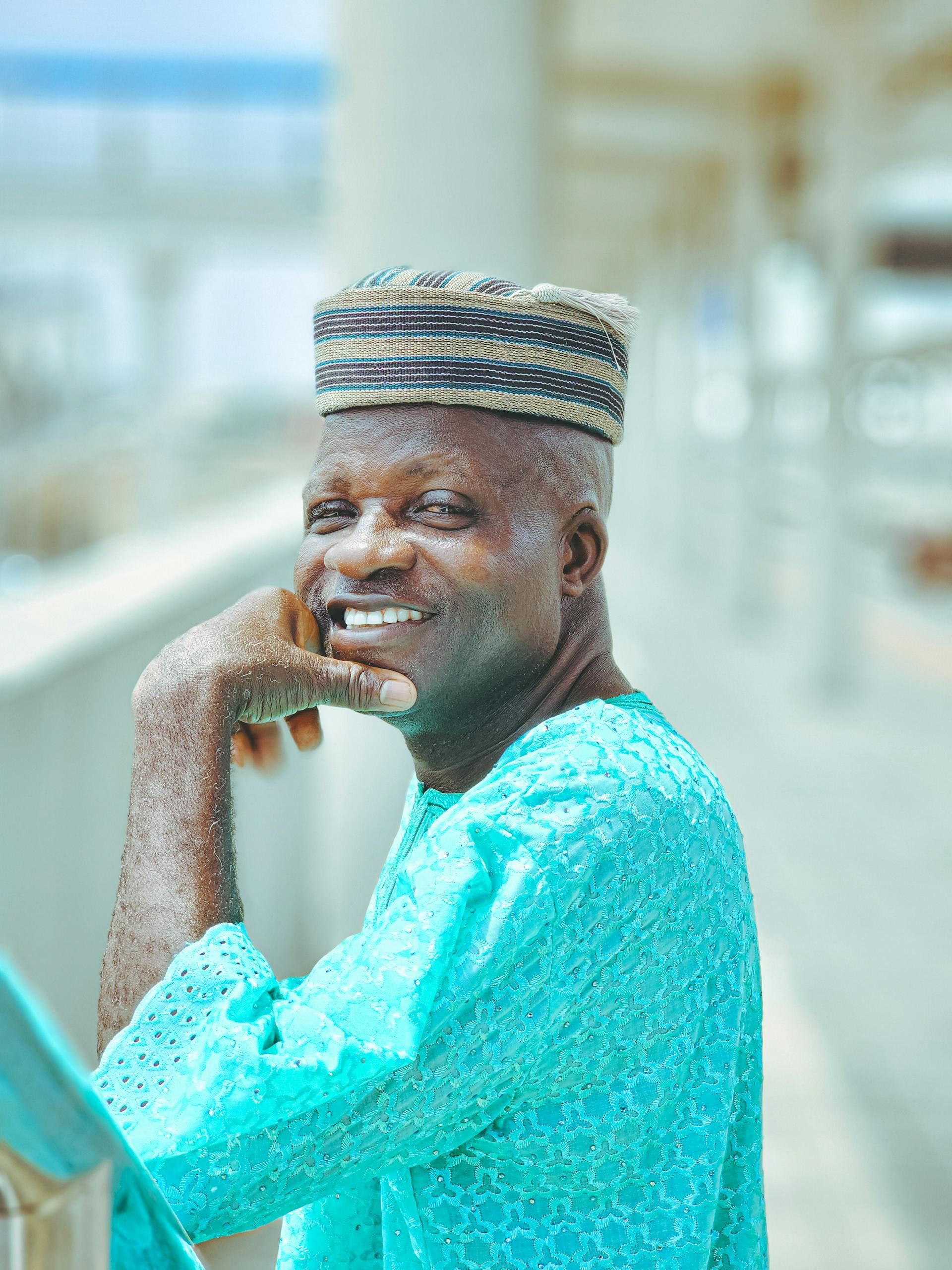 Portrait of a smiling man in traditional clothing posing outdoors. Bright and cheerful expression.