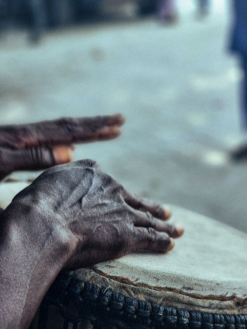 Free Detailed view of hands rhythmically playing a hand drum, capturing the texture of the skin and instrument. Stock Photo