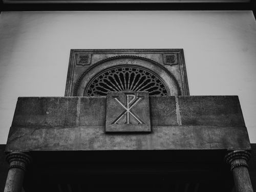 Free Black and white photo of architectural details featuring a Christian symbol on a building facade. Stock Photo