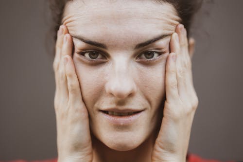 Selective Focus Portrait Photo of Woman Stretching Face