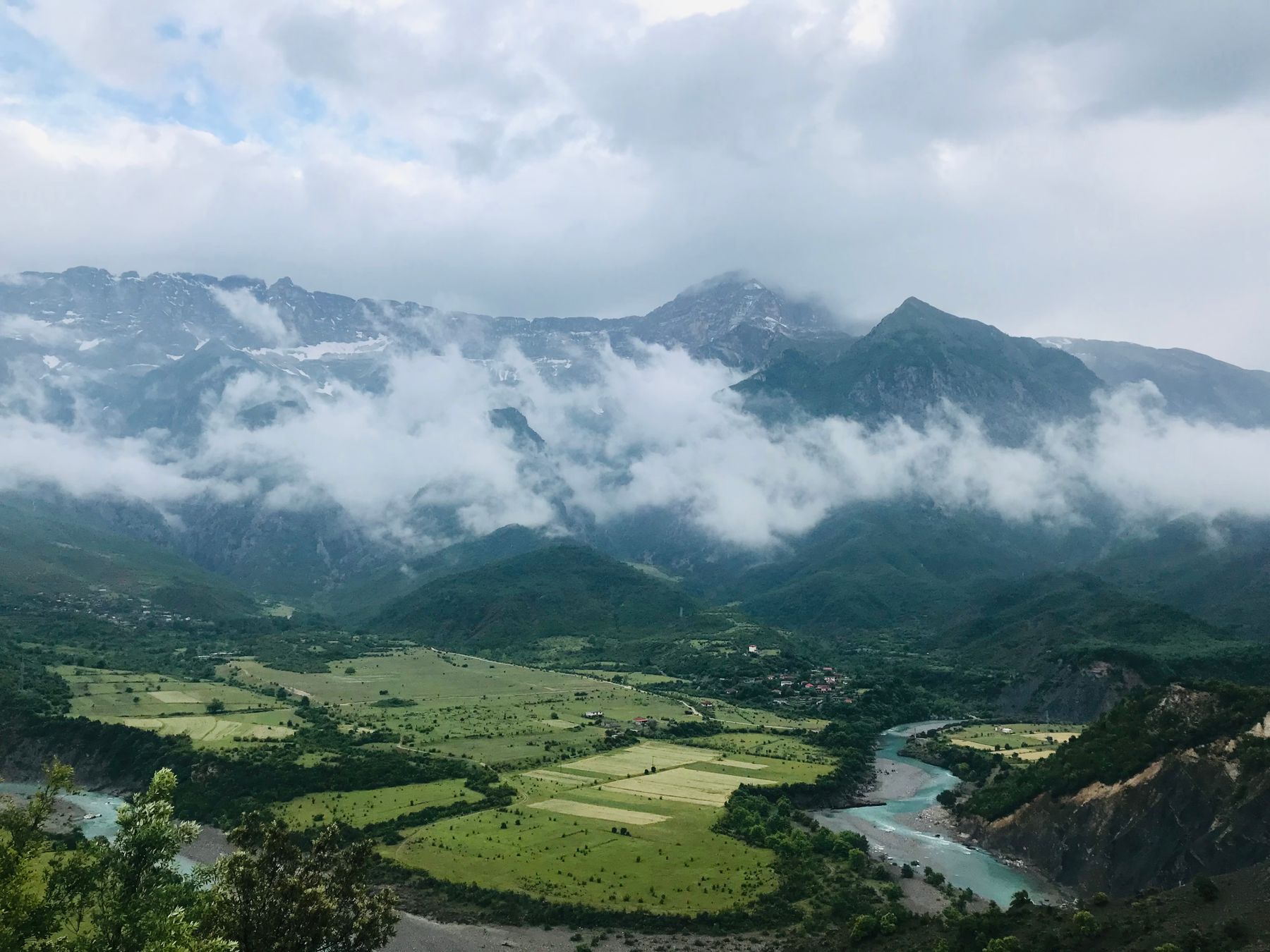 Stunning view of lush valleys and cloud-covered mountains in Përmet, Albania.