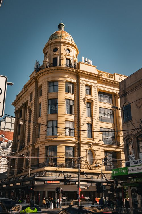 Free A historic yellow building with a dome in a bustling urban street. Stock Photo
