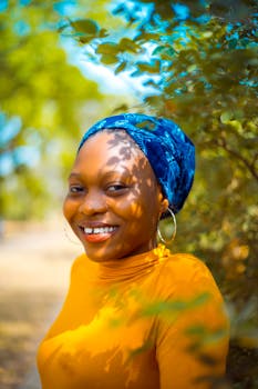 在自然环境中，一位戴着蓝色头巾、面带明亮微笑的女人