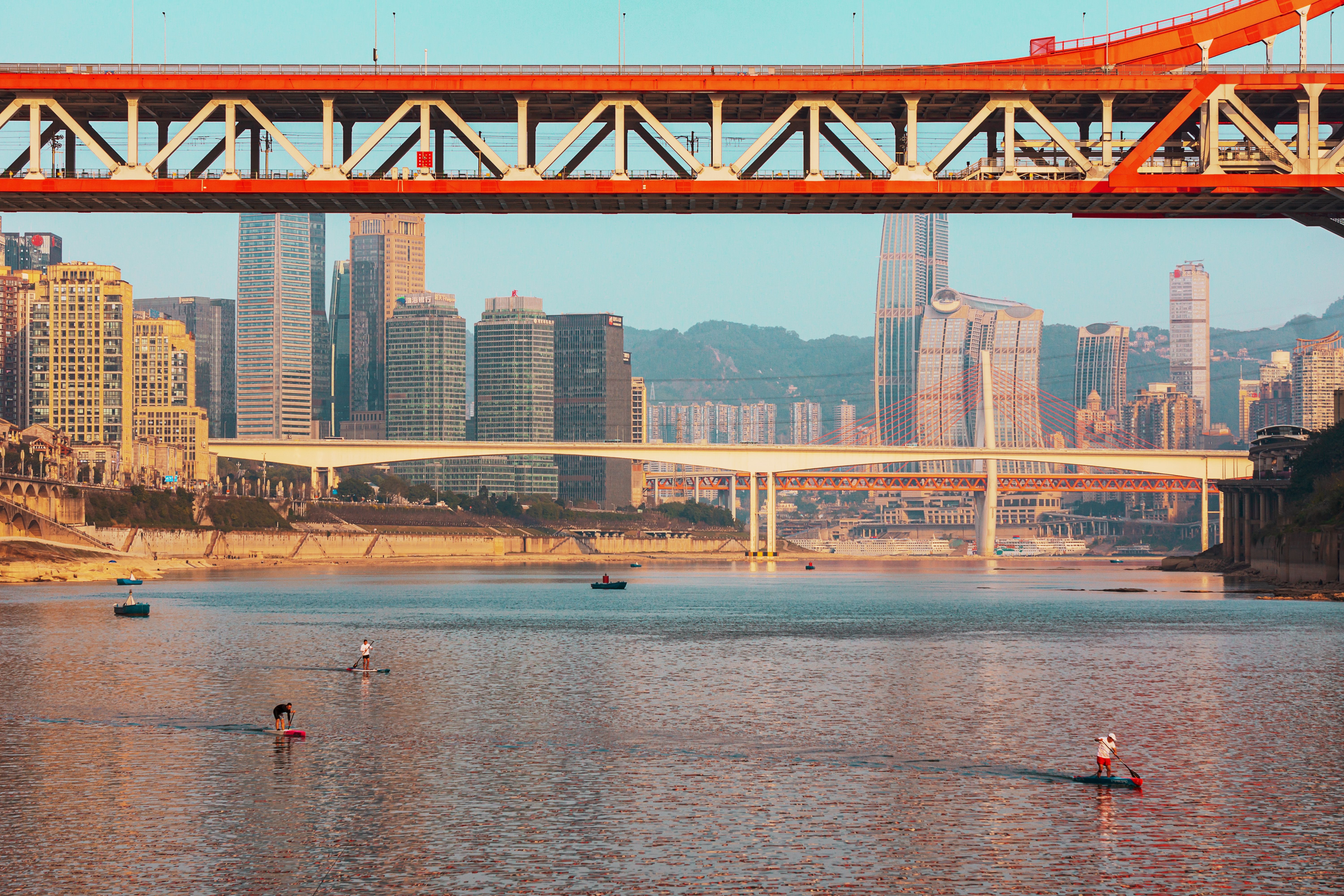 Modern cityscape with bridges and river activity · Free Stock Photo