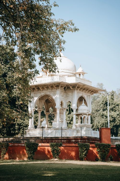 Free Stunning white marble pavilion amidst lush greenery on a sunny day. Stock Photo