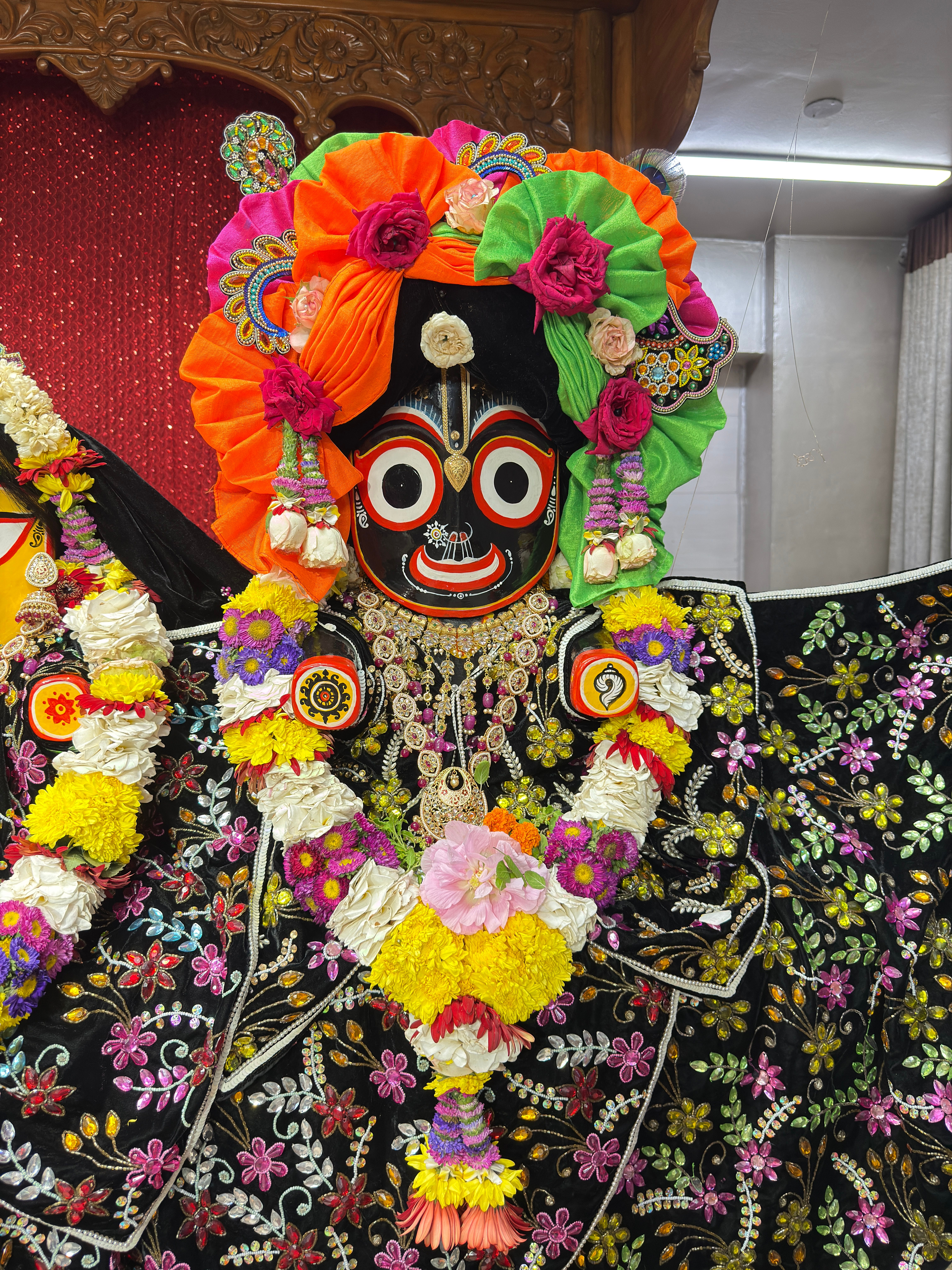 Colorful deity of Jagannath adorned with vibrant flowers and traditional attire.