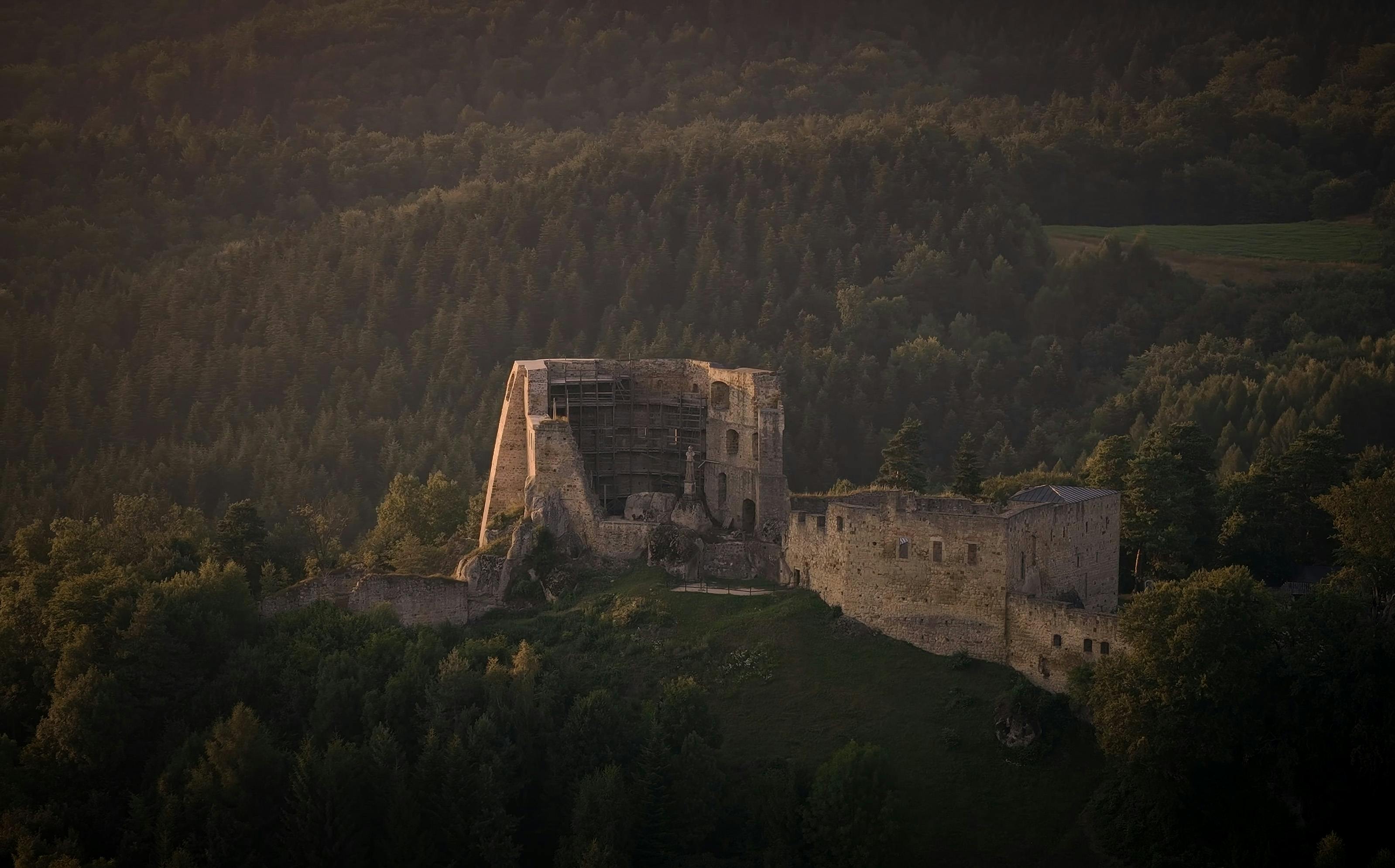 Aerial view of the historic Kamieniec Castle surrounded by lush greenery in Korczyna, Poland.