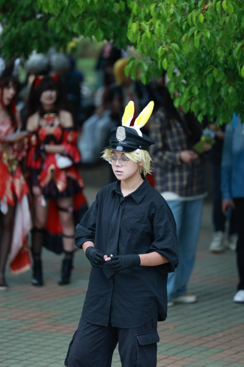 Free Cosplayer with bunny ears and police hat at outdoor event. Stock Photo