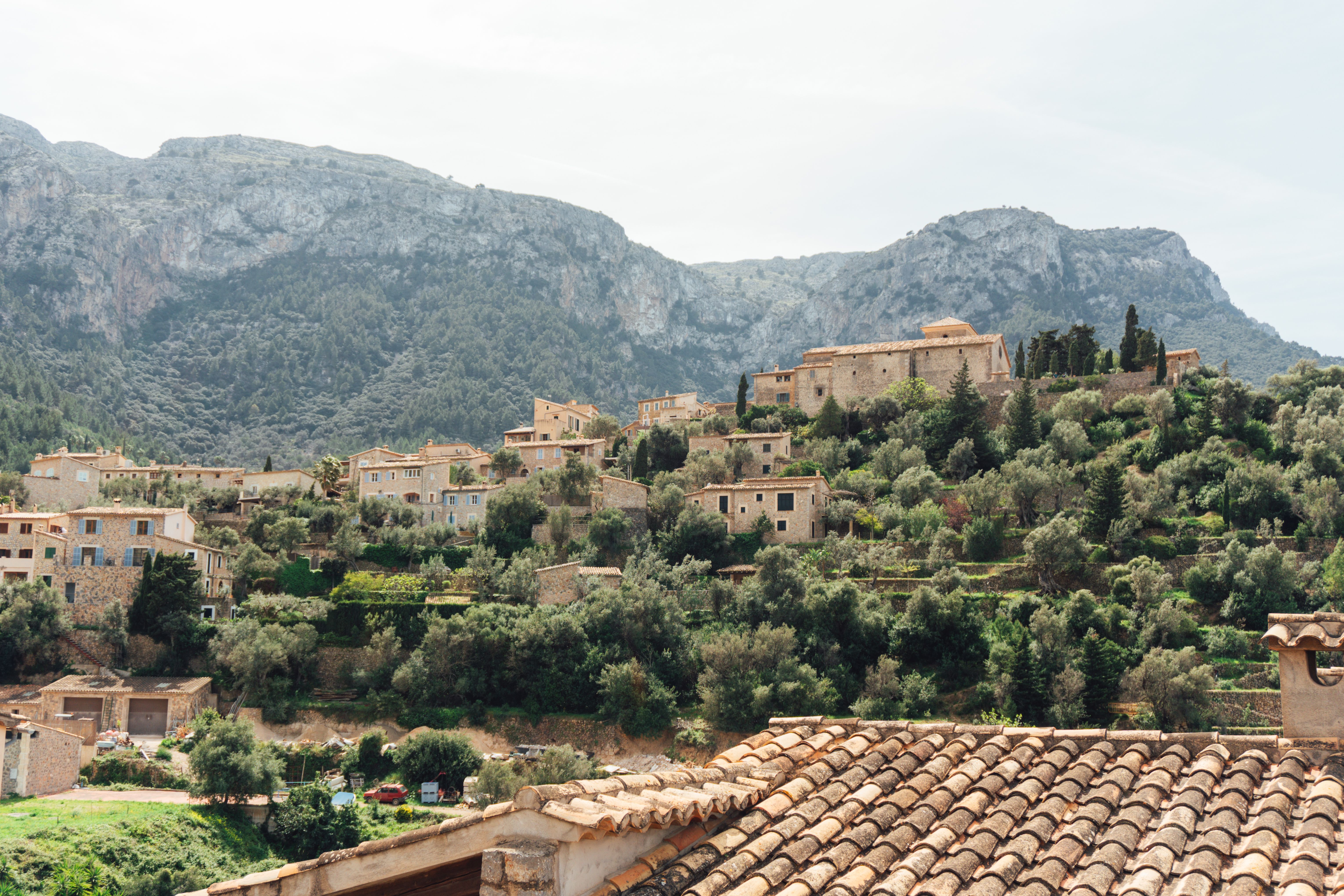 A stone village on a terraced hillside below the Tramuntana mountains
