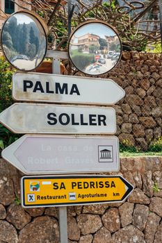 Signpost in Mallorca directs to Palma, Soller, and Sa Pedrissa, with mirrors reflecting scenery.