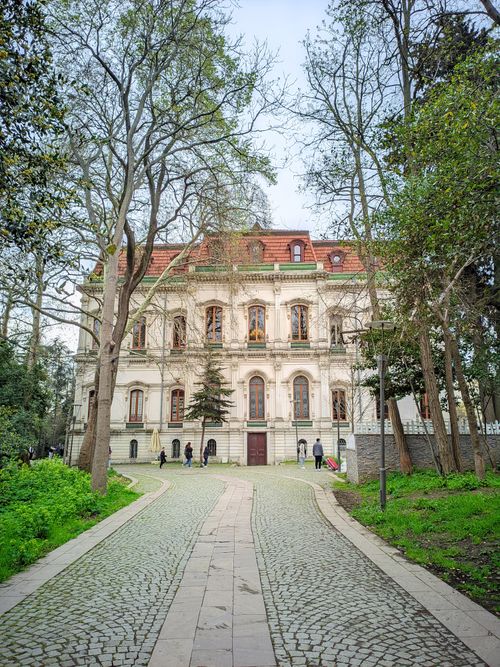 Free Beautiful historic building surrounded by lush greenery and trees on a spring day. Stock Photo