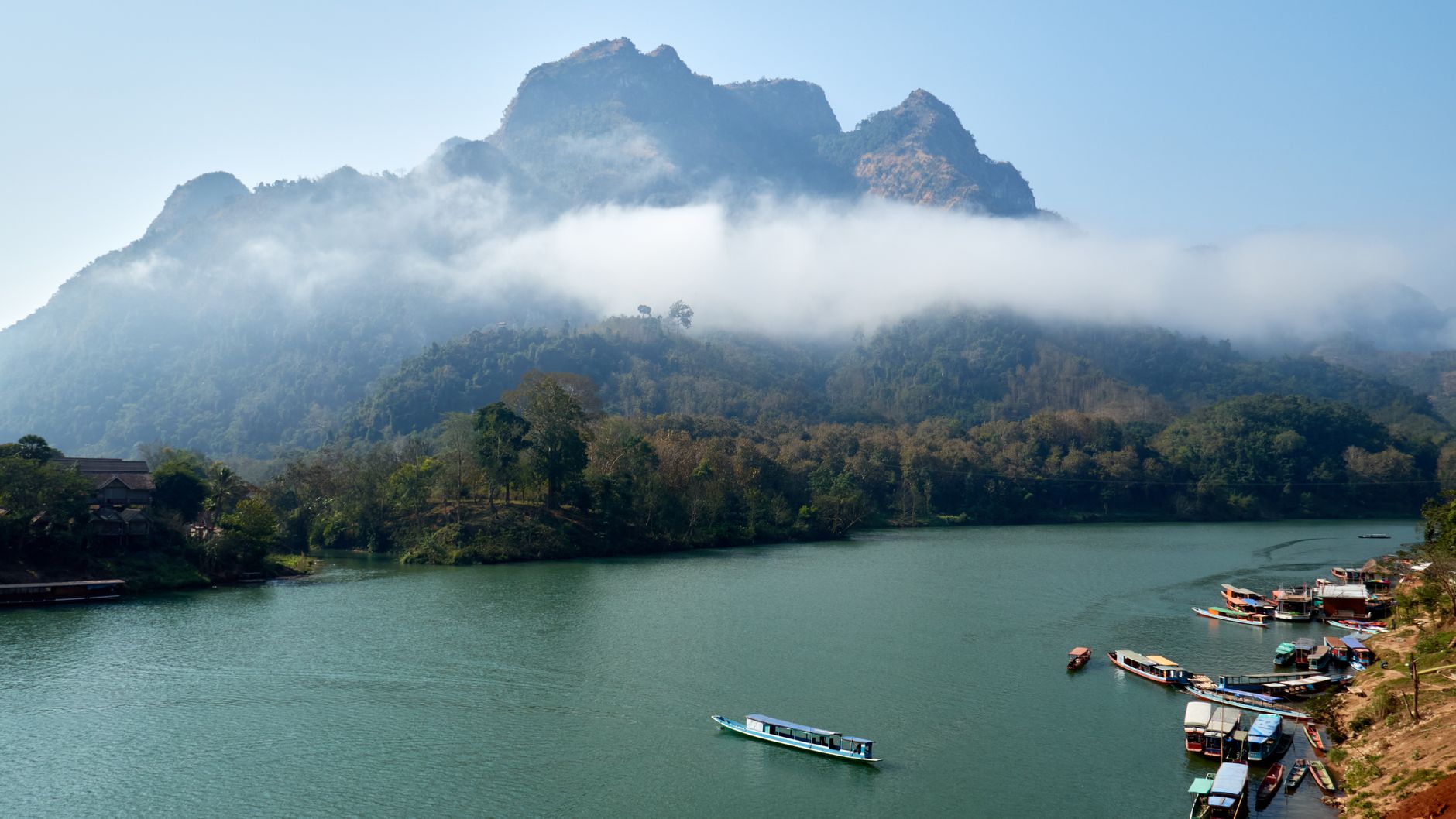 Breathtaking view of misty mountains and serene river in Nong Khiaw, Laos. Perfect for travel and nature enthusiasts.