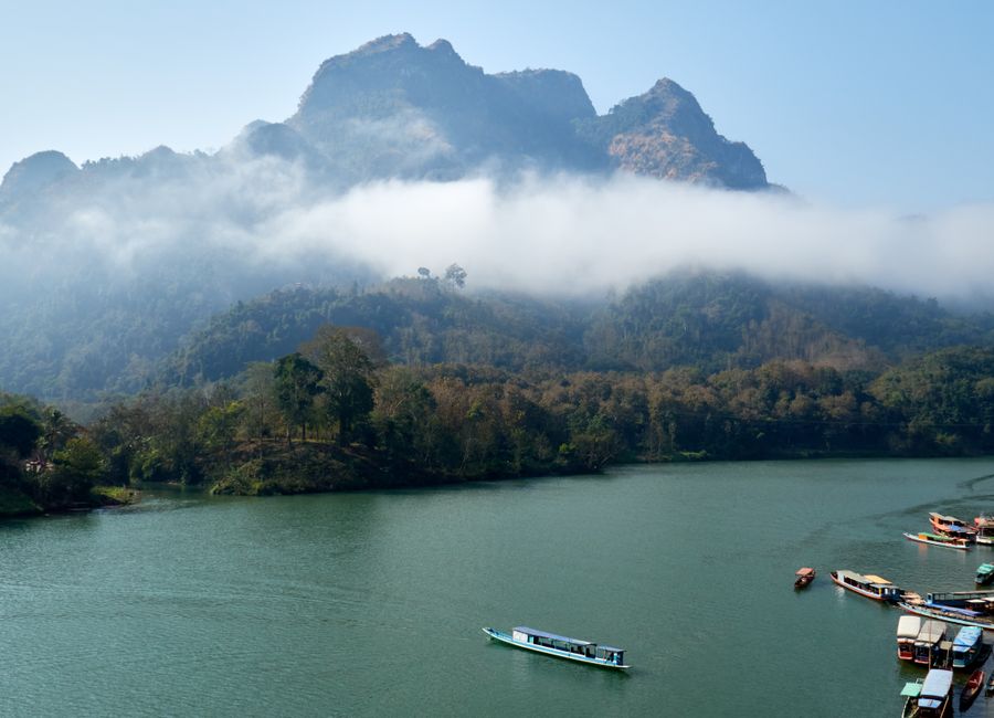 Breathtaking view of misty mountains and serene river in Nong Khiaw, Laos. Perfect for travel and nature enthusiasts.