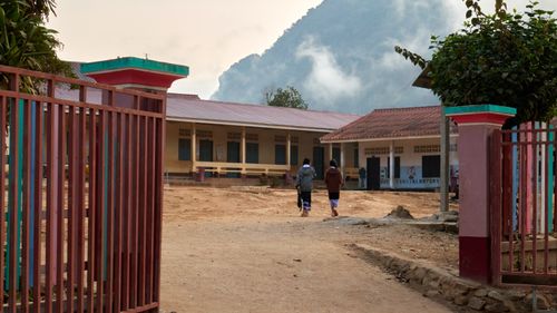 Students walking toward a rural village school in the Laos highlands