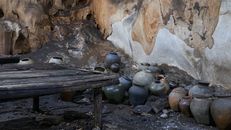 Ancient pottery jars in a cave in Laos, showcasing cultural history and heritage.