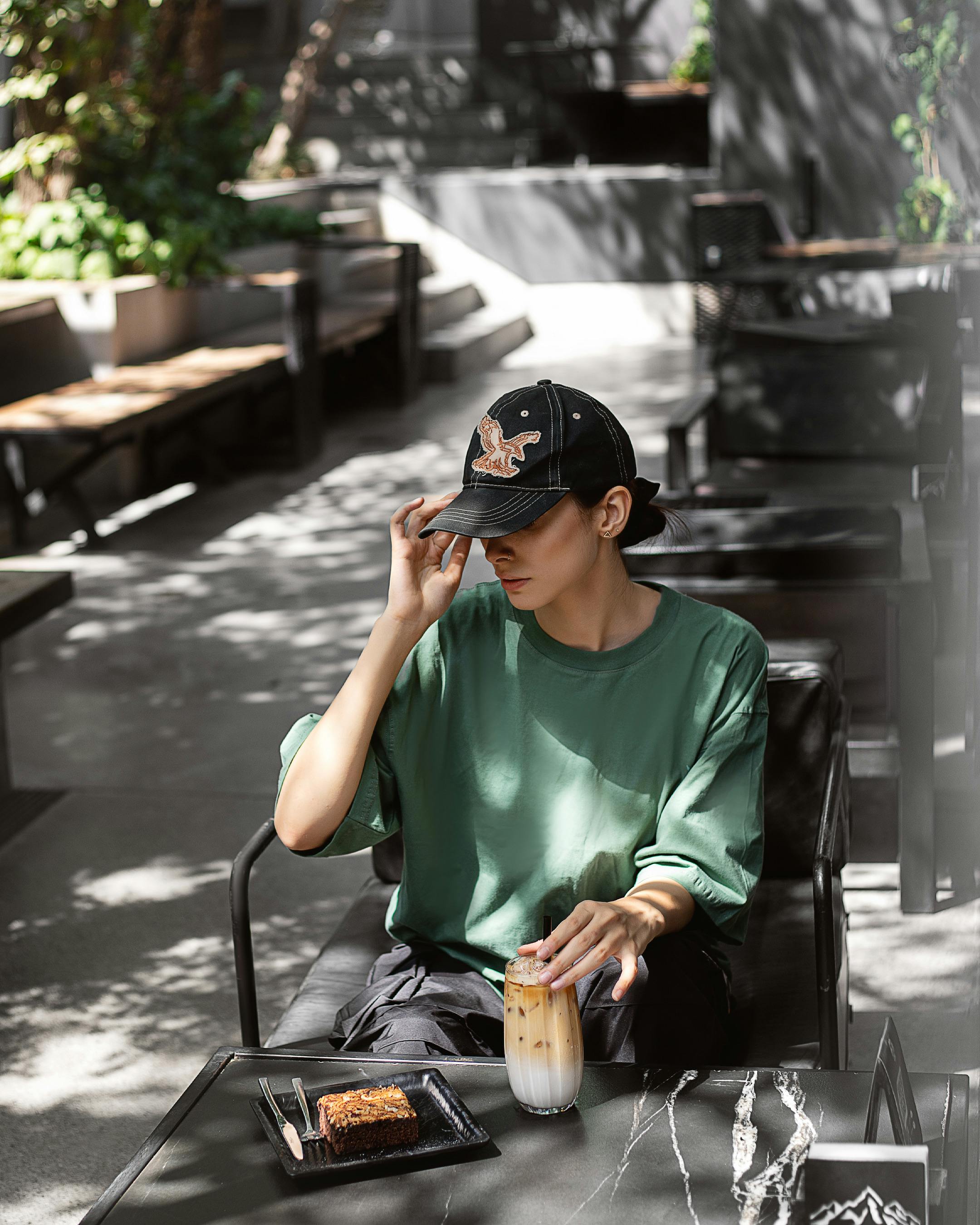 ingyenes Egy divatos ember egy kávézóban élvezi a jeges kávét a szabadban egy napsütéses napon. Stockfotó