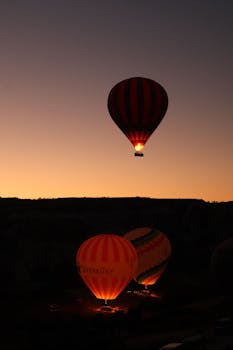 Breathtaking view of hot air balloons soaring over Cappadocia, Türkiye during sunrise.