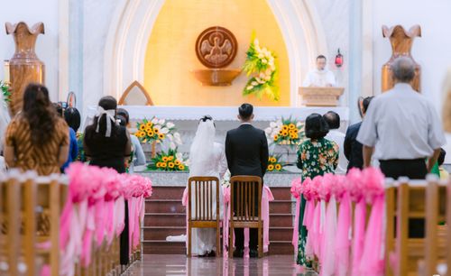 Free Church ceremony with a bride and groom, surrounded by guests and floral decor. Stock Photo