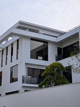 A sleek modern white building with large glass windows and minimalistic design.